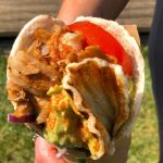 Gluten free wrap with meat, halloumi, avocado sauce, tomatoes, vegetables, onions