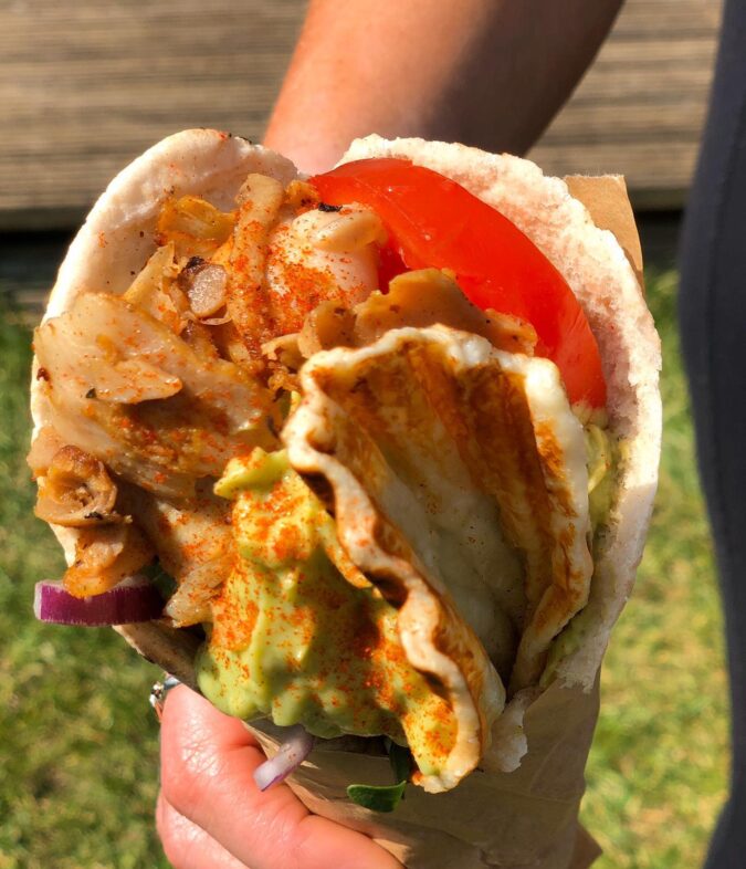 Gluten free wrap with meat, halloumi, avocado sauce, tomatoes, vegetables, onions